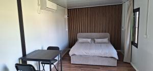 a small bedroom with a bed and a table at הבקתות של מאי 