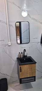 a bathroom with a sink and a mirror at הבקתות של מאי 