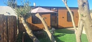 a house with a table and an umbrella in a yard at הבקתות של מאי 