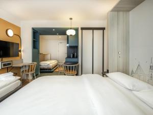 a bedroom with a large bed and a desk at Aparthotel Adagio access Hamburg in Hamburg