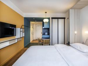 a hotel room with a large bed and a kitchen at Aparthotel Adagio access Hamburg in Hamburg +47 photos