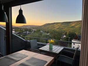 HTS Mosel Apartment Wanderlust Bernkastel Andel في بيرنكاستل كويز: شرفة مع طاولة وكراسي وإطلالة