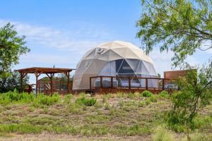a large dome house in a field with trees at Luxury Glamping Dome on Texas Farm in San Marcos