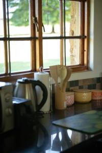 a kitchen counter with a coffee pot and a window at Blackbrook Farm Underberg in Underberg +33 photos