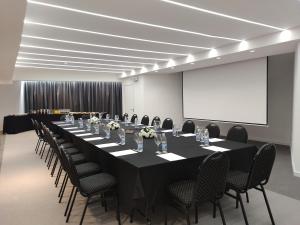 a conference room with a long table and chairs at Mercure Rosario in Rosario +68 photos