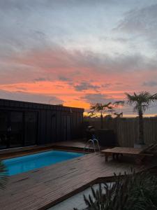 a backyard with a swimming pool and a sunset at Willa Zięba & SPA Domek Apartamenty nad Zalewem z Basenem, Jacuzzi i Sauną in Kańczuga