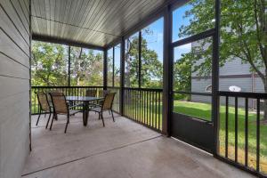 a screened in porch with a table and chairs at Stonebridge Hideaway - For 6 in Branson West