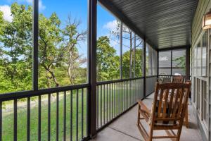 a screened in porch with a chair and windows at Stonebridge Hideaway - For 6 in Branson West