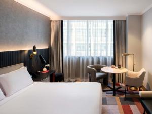 a hotel room with a bed and a table at The Sebel Sydney Martin Place in Sydney