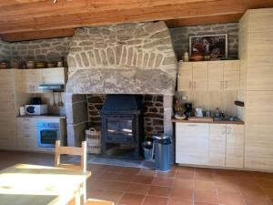 a kitchen with a stone fireplace in a kitchen at La maison des Florentins La Monédière in Chaumeil +14 photos