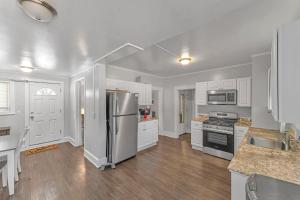 a kitchen with white cabinets and a stainless steel refrigerator at The Main Lineup 2 - All Star Baseball Rentals in Oneonta