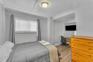 a bedroom with a bed and a desk and a television at The Main Lineup 2 - All Star Baseball Rentals in Oneonta