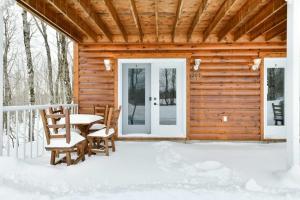 eine Holzhütte mit Tisch und Stühlen im Schnee in der Unterkunft Domaine Des Montagnais - Suite Astro 1 in Notre-Dame-Des-Bois