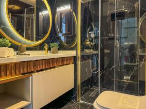 a bathroom with a shower and a toilet and mirrors at Qoople Legend B - premium apartments steps from the sea in Alanya