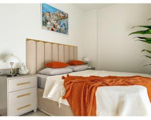 a bedroom with a bed with an orange blanket on it at Qoople Legend B - premium apartments steps from the sea in Alanya +55 photos