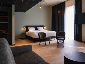 een hotelkamer met een bed en een bank bij Hotel Valkenburg by Mercure - Next to Shimano Experience Center in Valkenburg