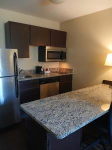 a kitchen with a granite counter top and a refrigerator at Mainstay Suites in Brentwood