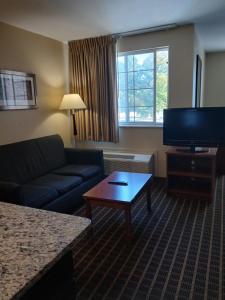 a living room with a couch and a flat screen tv at Mainstay Suites in Brentwood