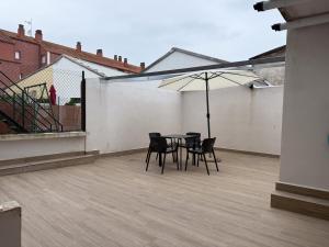 a patio with a table and chairs and an umbrella at Abastos in Santoña