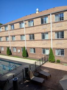 a large brick building with two chairs in front of it at Mainstay Suites in Brentwood