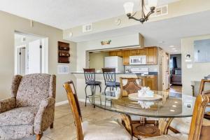 Un comedor y una cocina con una mesa de cristal y sillas. en Direct Oceanfront Condo Beautifully Remodeled, en Cabo Cañaveral 19 fotos más