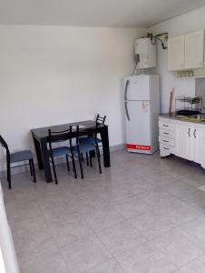 a kitchen with a black table and a refrigerator at Alquituc Escobar in Belén de Escobar