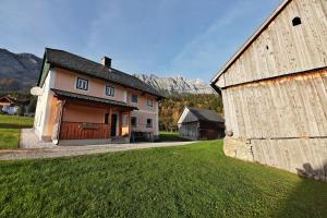 a house and a barn with mountains in the background at Ferienhaus Schwöllerbauer in Sankt Martin am Grimming