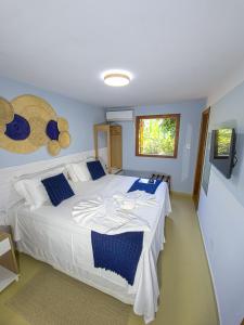 a bedroom with a large white bed with blue pillows at Pousada Céu da Chapadha in Mucugê +56 photos