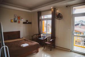 a bedroom with a bed and a table and a window at Sapa Central House in Sapa