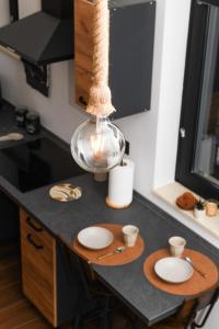 a kitchen with a table with plates and a light at Kocohouse Casa vacanze in Marino +5 photos