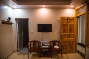 a room with a table and two chairs and a television at Sapa Central House in Sapa