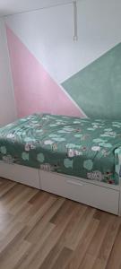 a bed with a green comforter in a room at Casa Ginguba in Saint-Émilion