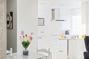 a white kitchen with a vase of flowers on a table at Fórum Glam 5B by Homie in Ilhéu do Gorgulho