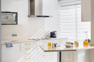 a kitchen with white cabinets and a counter top at Fórum Glam 5B by Homie in Ilhéu do Gorgulho