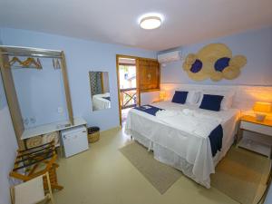 a bedroom with a bed and a desk and a window at Pousada Céu da Chapadha in Mucugê
