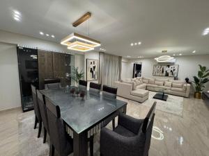 a dining room with a table and chairs and a couch at Charming Apartment - Near Cairo Airport in Cairo