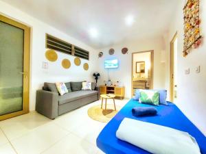 a living room with a blue bed and a couch at Logement de charme, au soleil et proche de la mer in Moorea