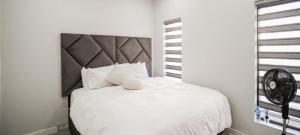 a bedroom with a white bed with a large headboard at LiFa Luxury Sandton Retreat in Johannesburg +10 photos