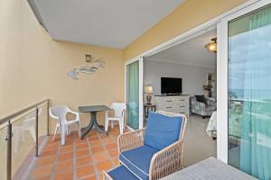 a room with a balcony with a table and chairs at Beachfront - Best Beach View Studio - E422-1 in Palm-Eagle Beach