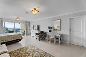 a bedroom with a bed and a desk and a room with a bed at Beachfront - Best Beach View Studio - E422-1 in Palm-Eagle Beach