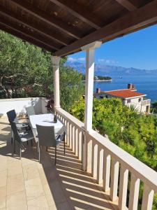 a porch with a table and chairs and a view of the ocean at Villa Albatros in Selca
