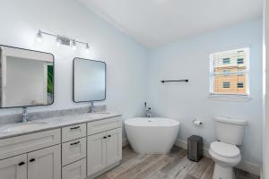 a bathroom with a sink and a toilet and a mirror at Blue Beak Bungalow in Pensacola