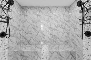 a marble shower with a glass counter in a bathroom at Blue Beak Bungalow in Pensacola