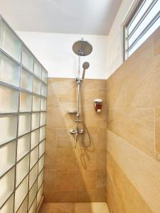a bathroom with a shower with a glass wall at Charmant logement avec accès privé à la plage in Moorea +33 photos