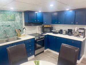 a kitchen with blue cabinets and a sink at Spacious Basement Lower Suite 3BR Home Stay 1 King 2 Queen Beds 2 Car Parkings FIFA 2026 in Pickering +26 photos