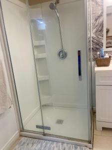a shower with a glass door in a bathroom at Spacious Basement Lower Suite 3BR Home Stay 1 King 2 Queen Beds 2 Car Parkings FIFA 2026 in Pickering