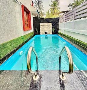 a swimming pool with two handles in a building at Sky Bloom Villa in Nagoa-Bardez