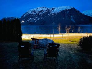 twee stoelen voor een meer en een berg bij JOlster apartaments in Årdal