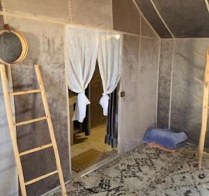 a room with a mirror and a ladder and a bed at Unique Luxury Camp in Merzouga +57 photos