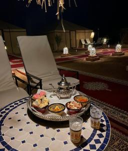 a tray of food on a table with two glasses of beer at Unique Luxury Camp in Merzouga